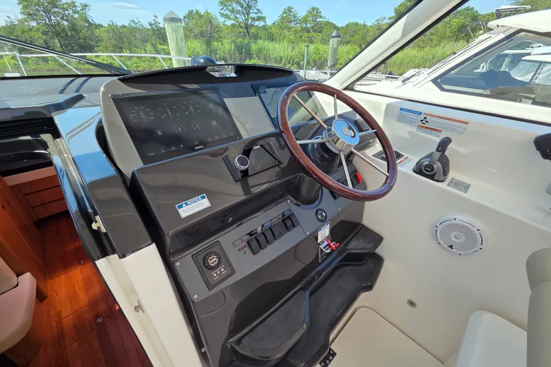 Slide: The Image of 2023 Tiara Yachts 4300 Open helm with steering wheel and control panel. - 15
