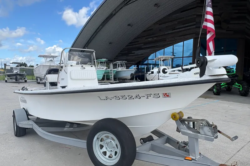 Slide: The Image of 2008 Kenner 19 VX boat on trailer, parked outside showroom with American flag. - 10