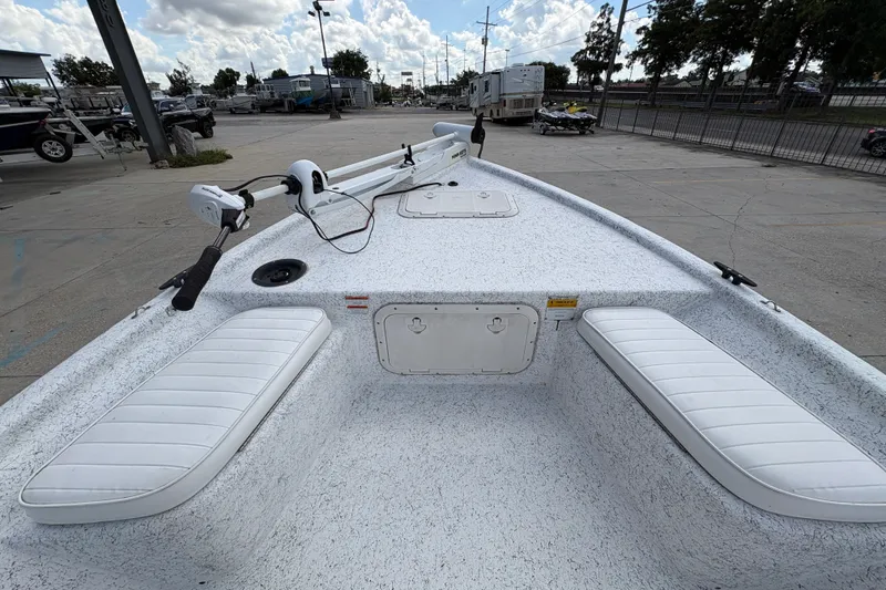 Slide: The Image of 2008 Kenner 19 VX boat interior with white seating and trolling motor, parked outdoors. - 20