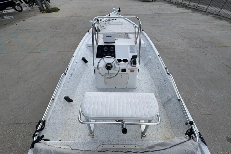 Slide: The Image of 2008 Kenner 19 VX boat with steering console and seating, parked on concrete. - 12