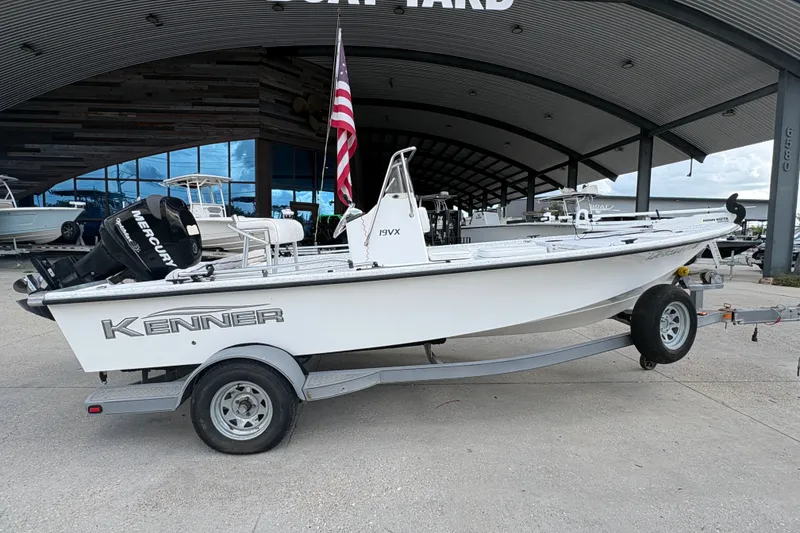 Slide: The Image of 2008 Kenner 19 VX boat on trailer with American flag, parked at marina. - 3
