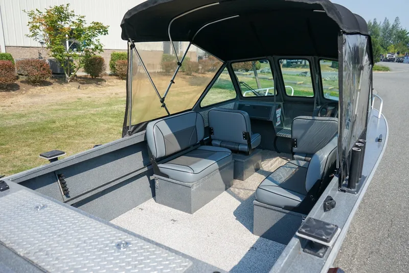 Slide: The Image of 2020 Alumaweld Blackhawk 180 boat interior with seating and canopy, parked outdoors. - 5