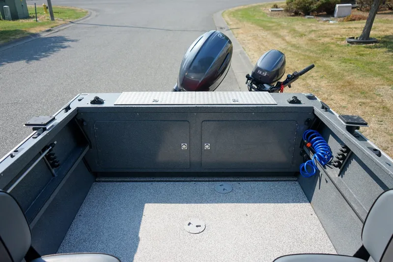 Slide: The Image of 2020 Alumaweld Blackhawk 180 boat interior with motor, storage, and coiled hose. - 6