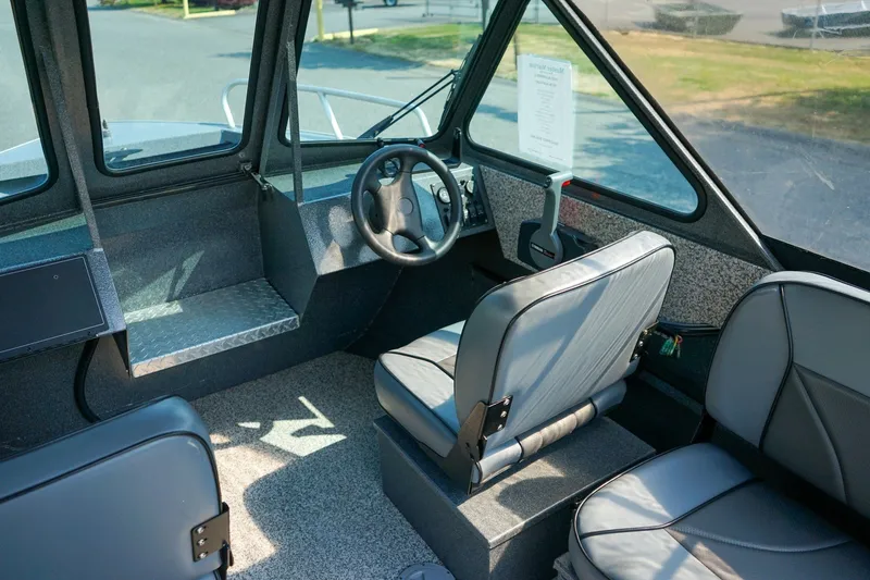 Slide: The Image of Interior of a 2020 Alumaweld Blackhawk 180 boat, featuring steering wheel and seating. - 11