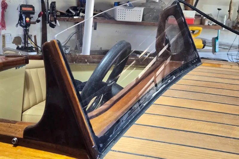 Slide: The Image of 2025 Florida Custom Boats 17 interior with wooden dashboard and steering wheel. - 16