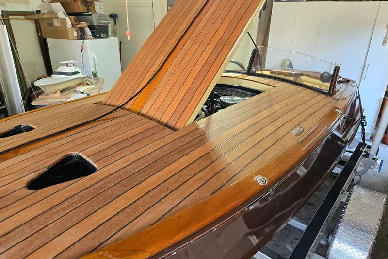Slide: The Image of 2025 Florida Custom Boats 17 with sleek wooden deck in a garage setting. - 14