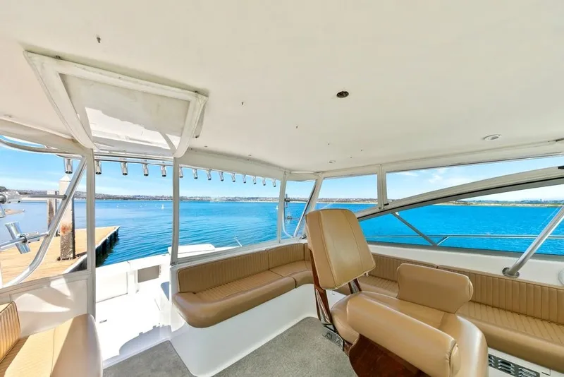 Slide: The Image of Interior view of a 1998 Viking 43 Open yacht with tan seating and ocean backdrop. - 6
