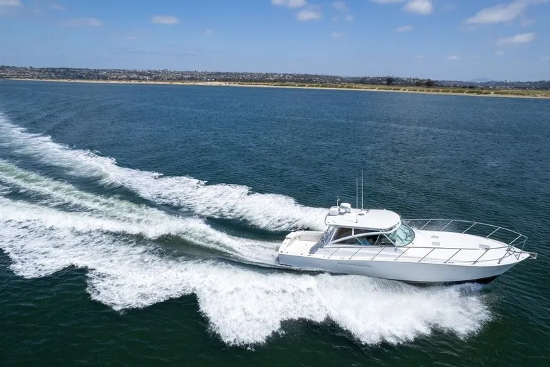 Slide: The Image of 1998 Viking 43 Open yacht cruising on open water under a clear blue sky. - 1