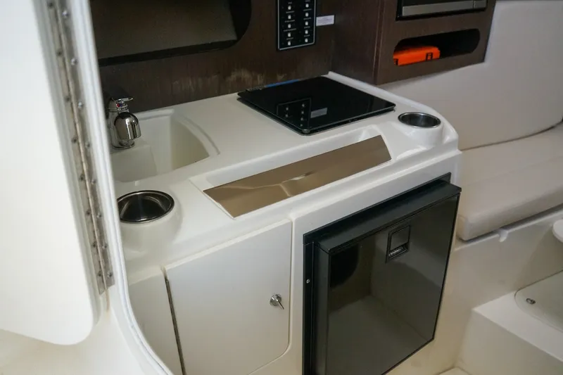 Slide: The Image of 2019 Striper 270 Walkaround boat interior with kitchenette, sink, and mini fridge. - 14