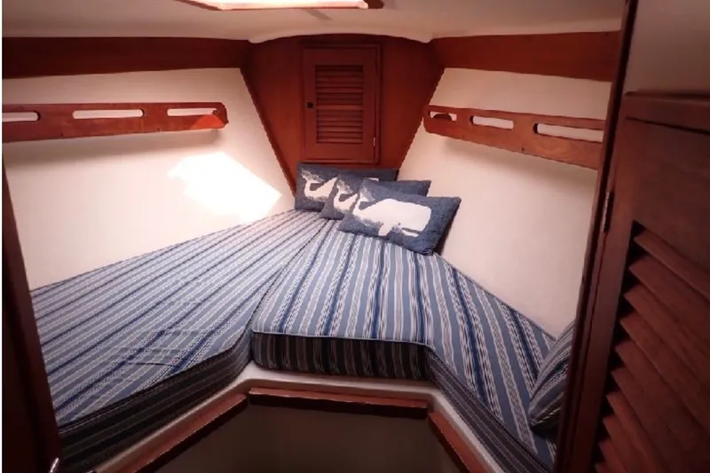 Slide: The Image of Cozy cabin interior of 1987 Tartan 34-2 sailboat with striped bedding and whale pillows. - 7