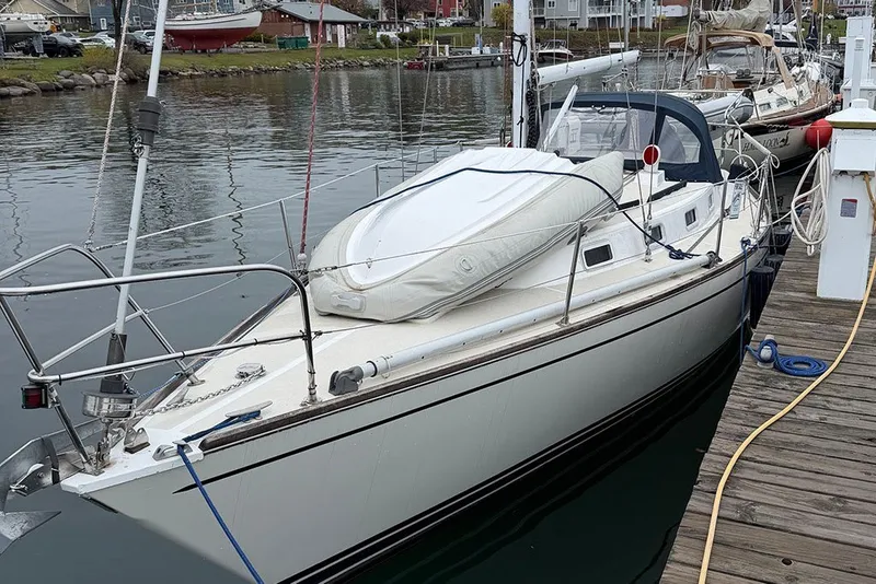 Slide: The Image of 1987 Tartan 34-2 sailboat docked at a marina, featuring a sleek design. - 2