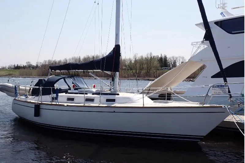 Slide: The Image of 1987 Tartan 34-2 sailboat docked on calm water, featuring sleek design and classic lines. - 1