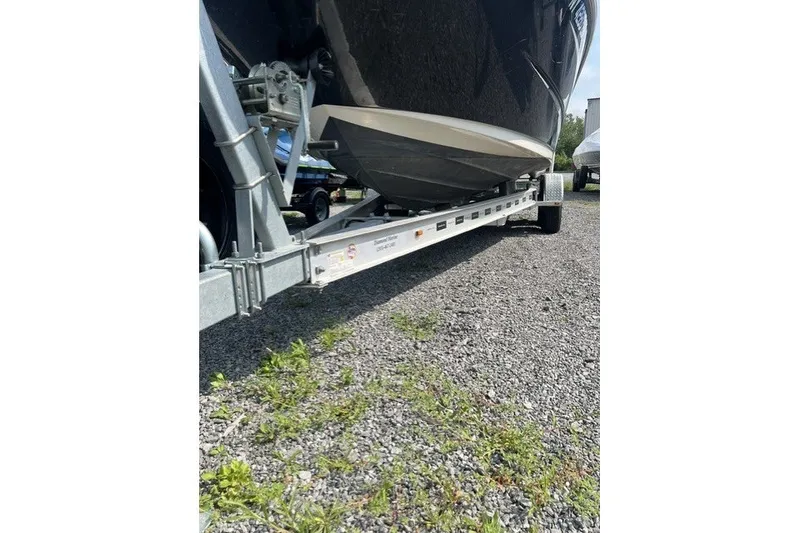Slide: The Image of 2010 Sea Ray 260 Sundeck boat on trailer, parked on gravel surface. - 28
