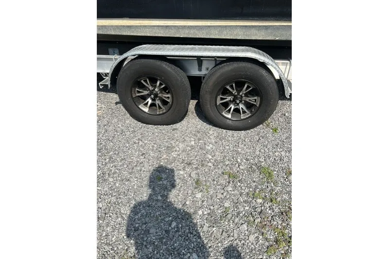 Slide: The Image of Trailer wheels of a 2010 Sea Ray 260 Sundeck on gravel surface. - 29