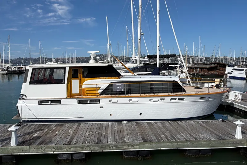 The Image of 1960 Chris-Craft 50 Constellation yacht docked at marina under clear blue sky. - 0