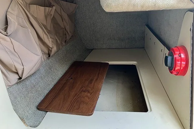 Slide: The Image of Interior of a 1984 S2 6.9 sailboat with storage compartment and red valve. - 8