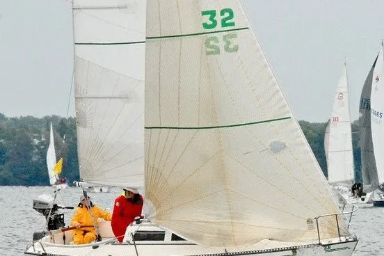 Slide: The Image of Sailboat S2 6.9 from 1984 racing on a lake with crew onboard. - 0