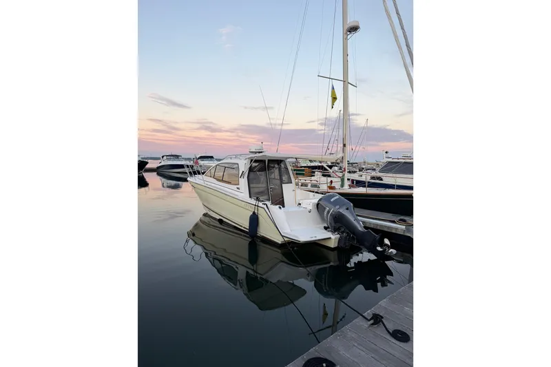 Slide: The Image of 2018 Cutwater C-24 boat docked at sunset, reflecting on calm water. - 4