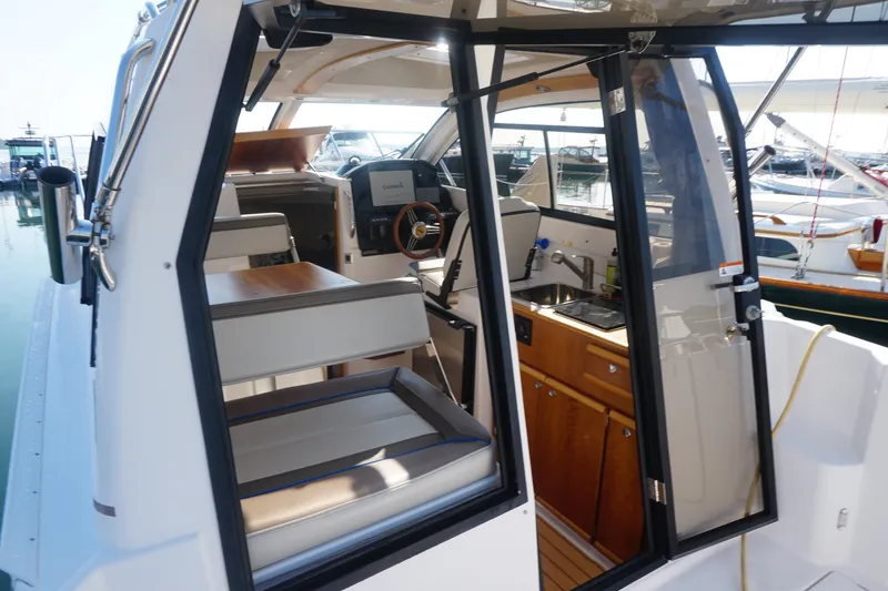 Slide: The Image of Interior view of a 2018 Cutwater C-24 boat, featuring seating and a compact kitchen area. - 35