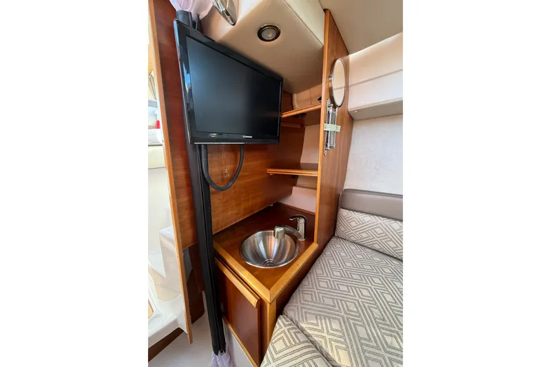 Slide: The Image of 2018 Cutwater C-24 interior with TV, sink, and patterned seating. - 9