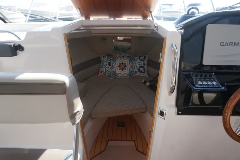 Slide: The Image of Interior cabin of a 2018 Cutwater C-24 boat with cushions and wooden accents. - 23