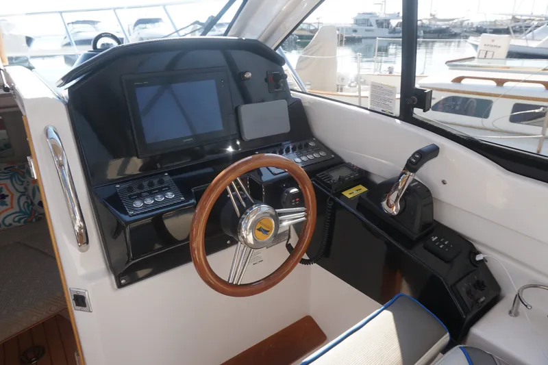 Slide: The Image of Helm of 2018 Cutwater C-24 boat with steering wheel and navigation controls. - 24