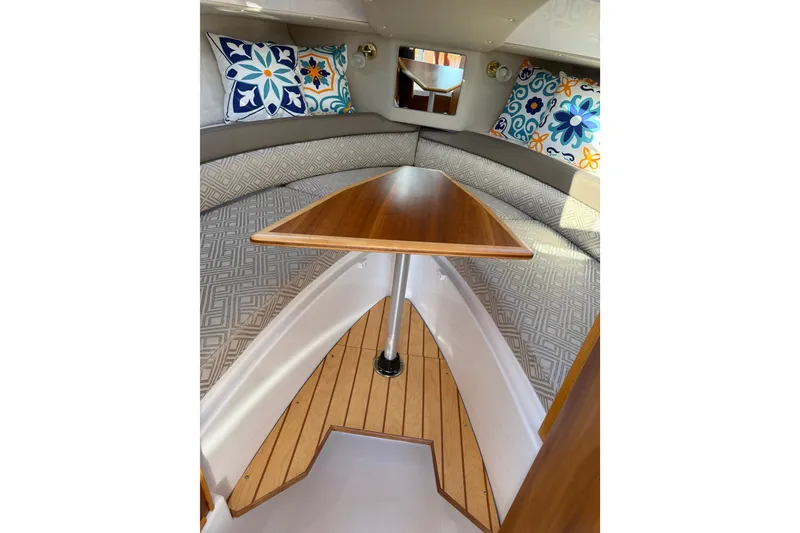 Slide: The Image of 2018 Cutwater C-24 cabin interior with wooden table and patterned cushions. - 6