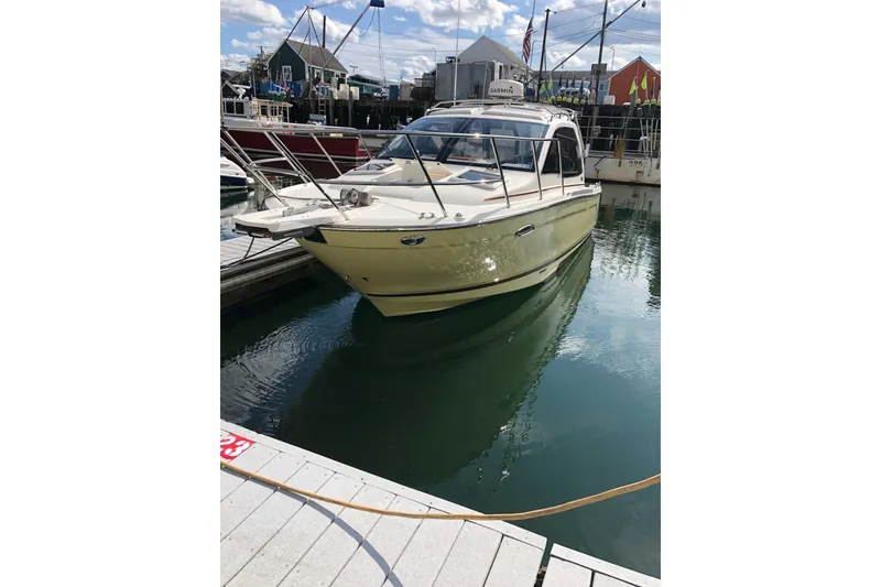 Slide: The Image of 2018 Cutwater C-24 boat docked in a marina under a clear sky. - 2