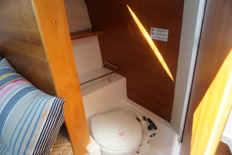 Slide: The Image of 2018 Cutwater C-24 boat interior with compact marine toilet and striped cushion. - 27