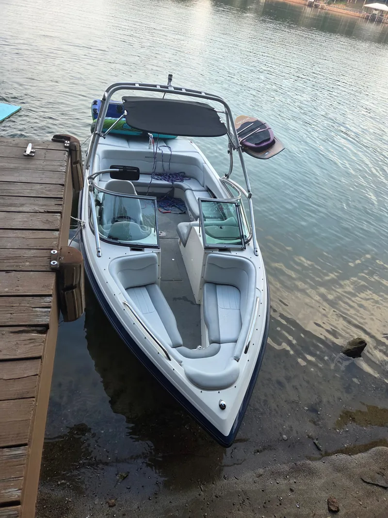 Slide: The Image of A 2003 MasterCraft X-30 docked at a wooden pier. It features white upholstery and an open cockpit. - 3