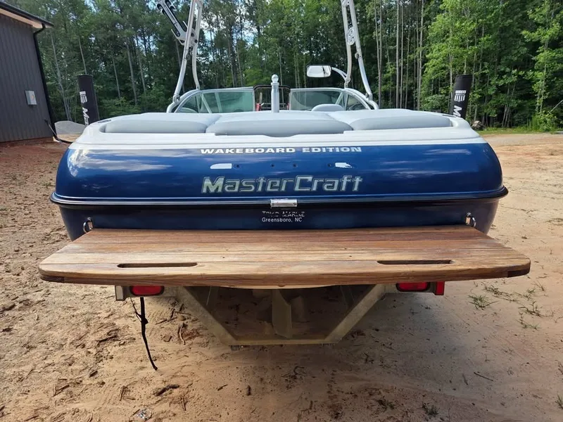 Slide: The Image of Rear view of a blue 2003 MasterCraft X-30 wakeboard boat with a wooden platform. - 4