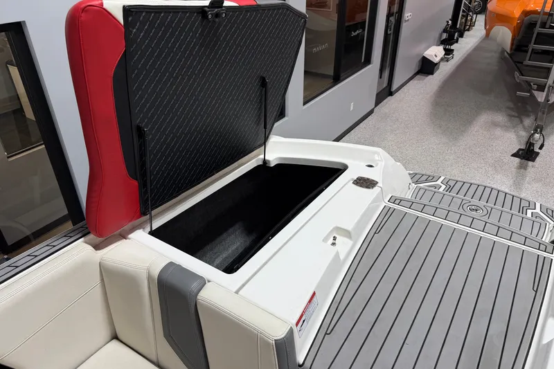 Slide: The Image of 2019 Nautique Super Air Nautique G25 boat storage compartment with open lid, red and white seating. - 23