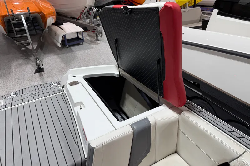 Slide: The Image of 2019 Nautique Super Air Nautique G25 boat with open storage compartment and red seat. - 22
