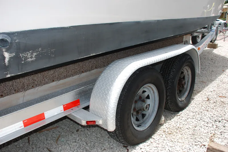 Slide: The Image of 2003 Grady-White Chase 273 boat on a dual-axle trailer, parked on gravel. - 27