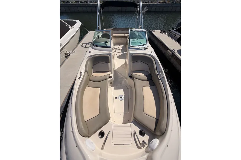 Slide: The Image of 2005 Sea Ray 240 Sundeck boat with spacious seating, docked at a marina. - 21