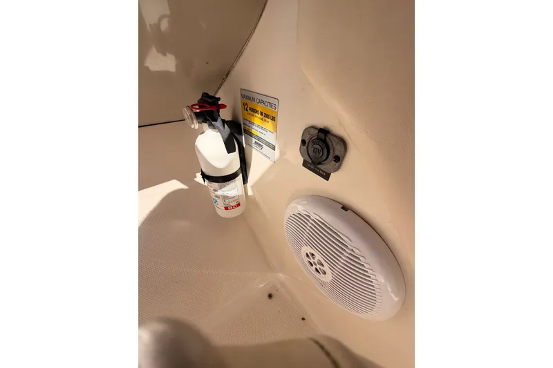 Slide: The Image of 2005 Sea Ray 240 Sundeck interior with fire extinguisher, speaker, and capacity label. - 34