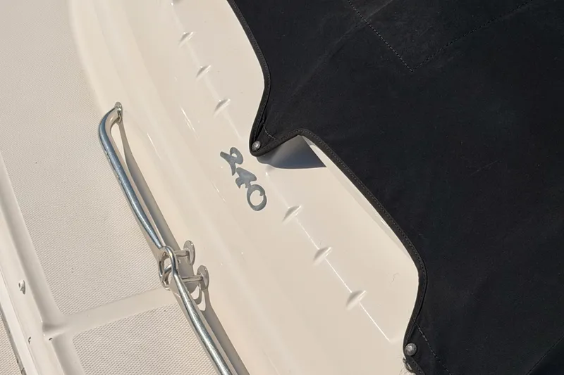 Slide: The Image of 2005 Sea Ray 240 Sundeck boat with black cover and metal railing. - 38