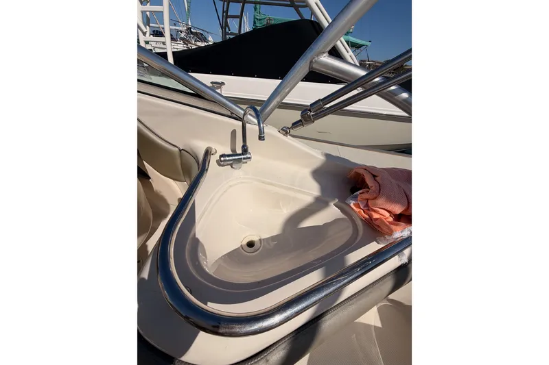 Slide: The Image of 2005 Sea Ray 240 Sundeck boat sink with faucet and towel on deck. - 26