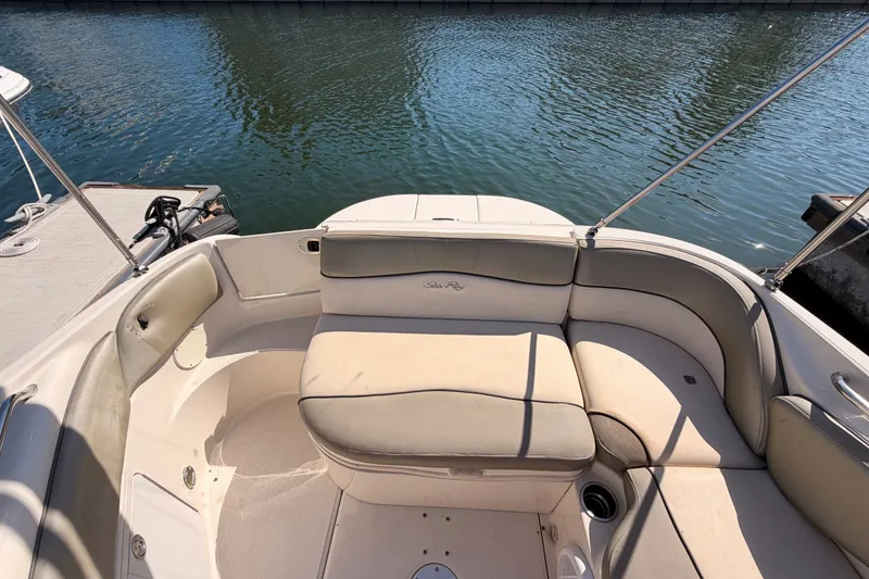 Slide: The Image of 2005 Sea Ray 240 Sundeck boat interior with cushioned seating by the water. - 36