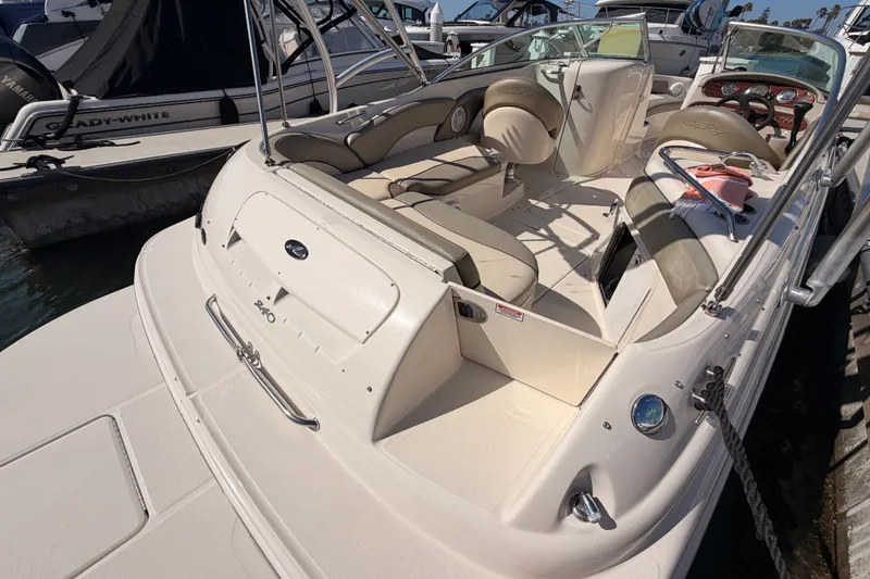 Slide: The Image of 2005 Sea Ray 240 Sundeck boat with spacious seating and sleek design at a marina. - 9
