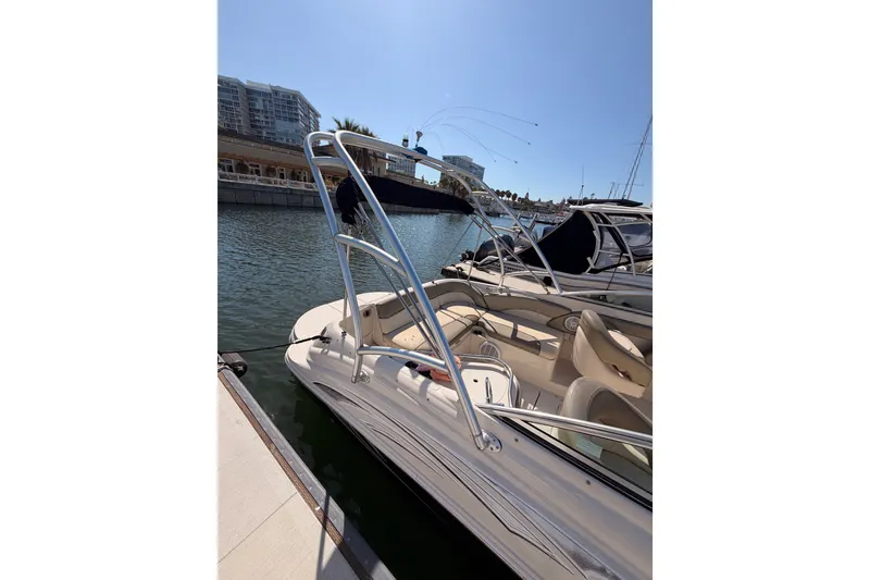 Slide: The Image of 2005 Sea Ray 240 Sundeck boat docked in a marina under clear skies. - 5