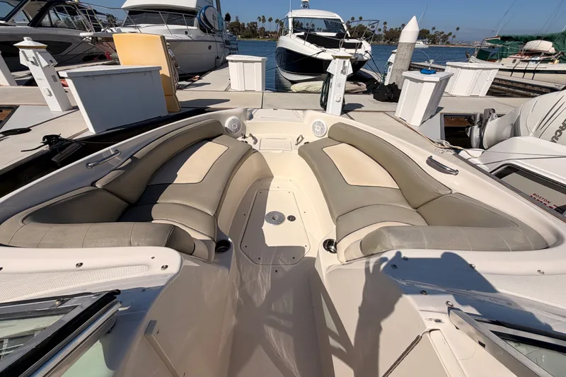 Slide: The Image of 2005 Sea Ray 240 Sundeck boat interior at marina, featuring spacious seating and elegant design. - 16