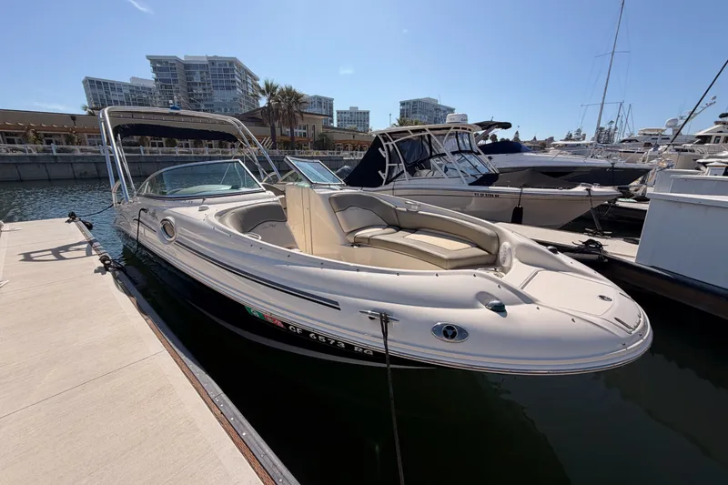 Slide: The Image of 2005 Sea Ray 240 Sundeck boat docked at marina under clear blue sky. - 3