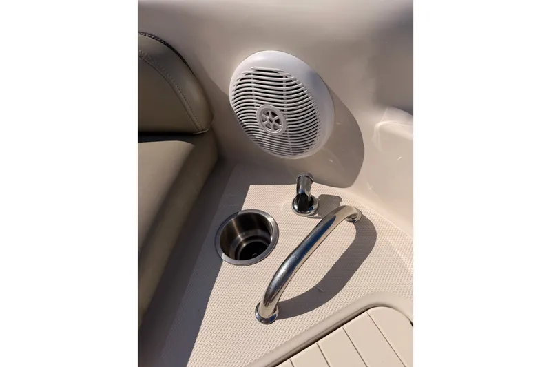 Slide: The Image of 2005 Sea Ray 240 Sundeck interior with speaker, cup holder, and handrail. - 19