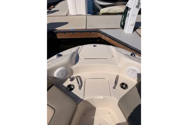 Slide: The Image of 2005 Sea Ray 240 Sundeck boat interior with seating and speakers at dock. - 18