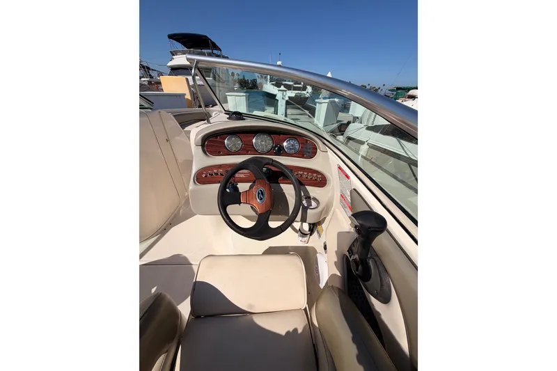 Slide: The Image of 2005 Sea Ray 240 Sundeck boat dashboard with steering wheel and gauges. - 12