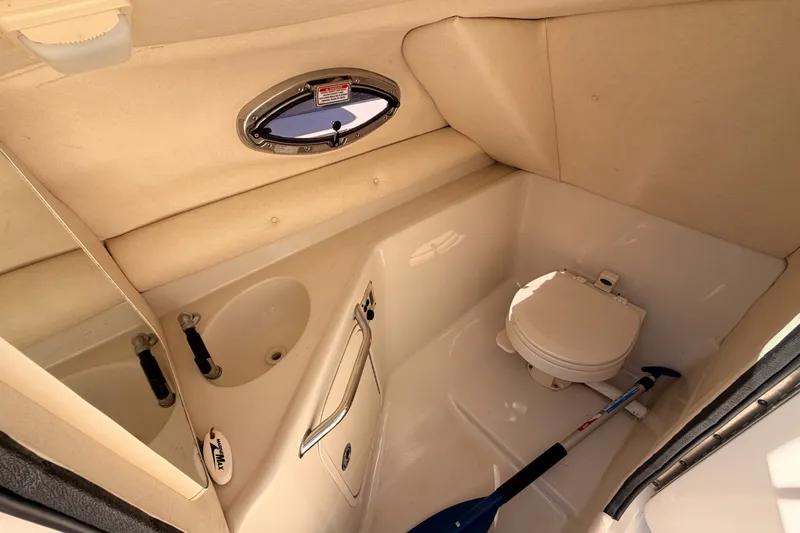 Slide: The Image of Interior of 2005 Sea Ray 240 Sundeck boat bathroom with toilet and sink. - 15