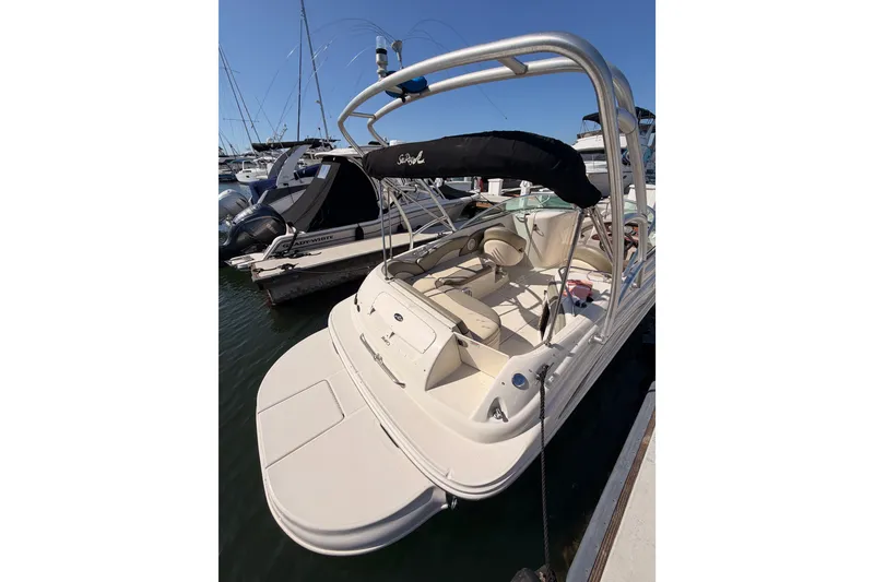 Slide: The Image of 2005 Sea Ray 240 Sundeck boat docked at marina, featuring spacious seating and sleek design. - 7