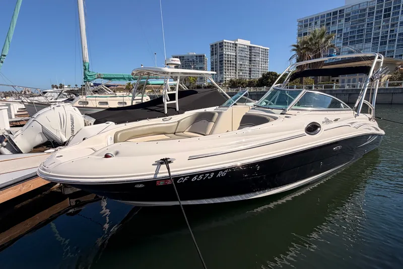 The Image of 2005 Sea Ray 240 Sundeck boat docked in marina, surrounded by other vessels. - 0