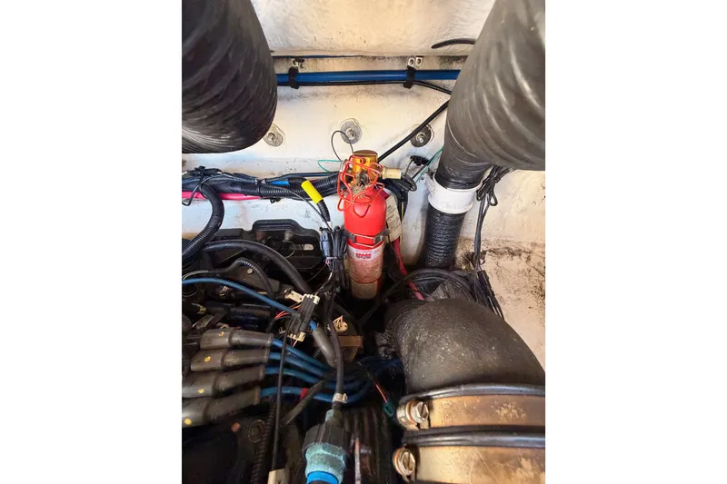 Slide: The Image of Engine compartment of a 2005 Sea Ray 240 Sundeck with fire extinguisher and wiring. - 31